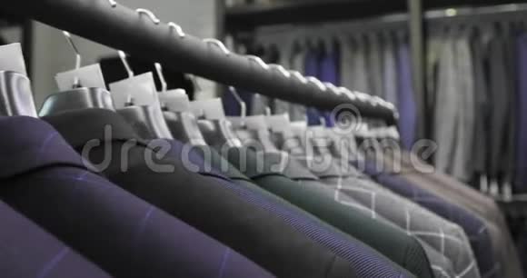 一排男人在衣架上穿夹克商店里挂在衣架上的新漂亮衣服视频的预览图