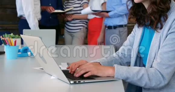 微笑的商务主管使用笔记本电脑视频的预览图