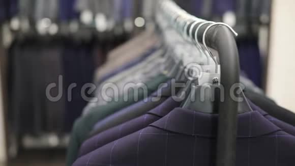 一排男式西装外套挂在衣架上收集新的漂亮衣服挂在商店的衣架上视频的预览图