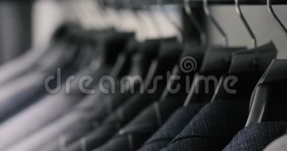 一排男式西装外套挂在衣架上收集新的漂亮衣服挂在商店的衣架上视频的预览图