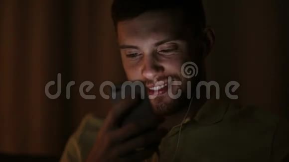 晚上带智能手机和耳机的男人视频的预览图