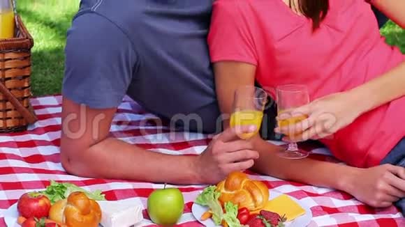 野餐时一对微笑的夫妇坐在毯子上视频的预览图