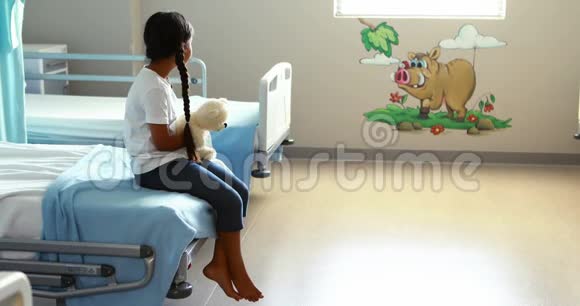 带着玩具熊坐在床上的生病女孩视频的预览图