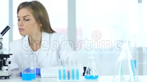 女科学家在实验室里观察瓶中的蓝色溶液视频的预览图