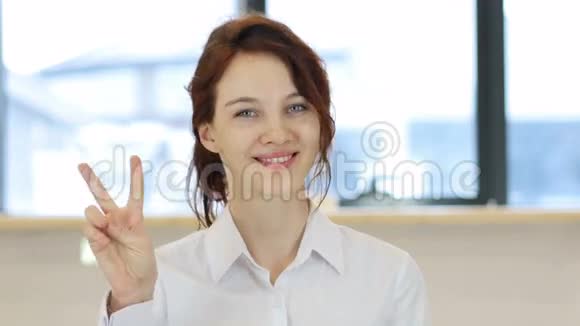 胜利手势女人在办公室视频的预览图