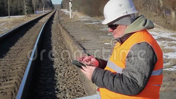 在铁路附近有平板电脑的铁路员工视频的预览图