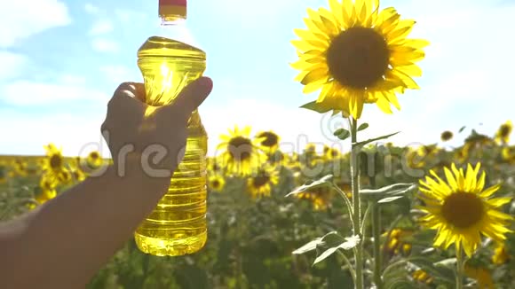 农夫手里拿着一瓶塑料生活方式的葵花籽油在他的手里的阳光下慢动作视频农业视频的预览图