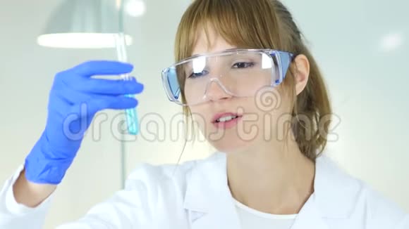 实验室里拿着蓝色溶液的女科学家视频的预览图