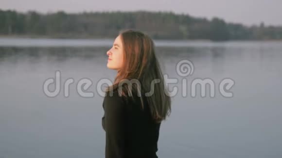 穿黑色衣服的女孩在日出的海滩上散步视频的预览图