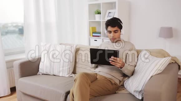 带平板电脑和耳机的男人视频的预览图