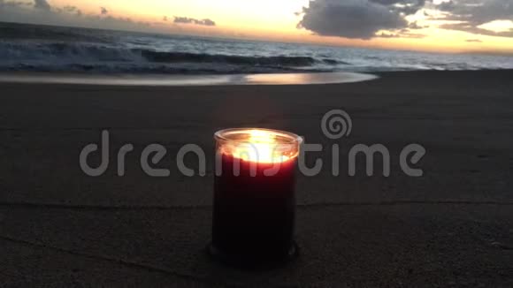 在夏威夷考艾岛的凯卡哈海滩太阳落山时用两种火焰燃烧着丁香和紫罗兰蜡烛视频的预览图