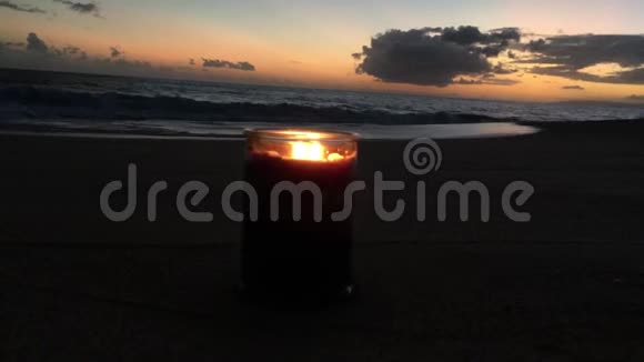 在夏威夷考艾岛的凯卡哈海滩太阳落山时用两种火焰燃烧着丁香和紫罗兰蜡烛视频的预览图