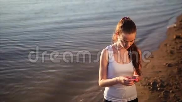 年轻女人在外面用智能手机视频的预览图