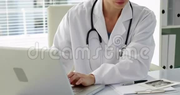医生在笔记本电脑上打字对着相机微笑视频的预览图