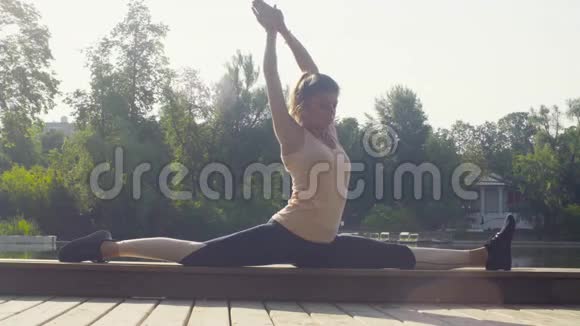 在公园做瑜伽运动的年轻女子视频的预览图