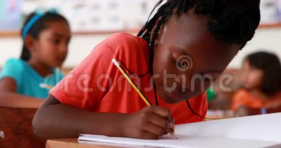 上课时小女孩在相机边写字边笑视频的预览图