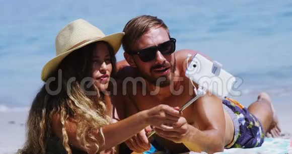一对情侣在沙滩上用手机自拍视频的预览图