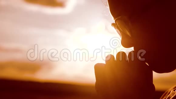 女孩祈祷女孩在日落时双手交叉祈祷剪影慢动作视频女孩双手交叉祈祷视频的预览图
