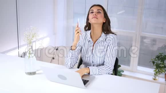 女人在工作时打电话在智能手机上谈判视频的预览图
