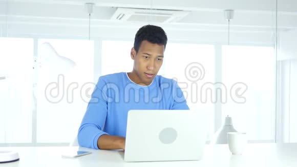 在办公室用笔记本电脑工作的非裔美国人视频的预览图