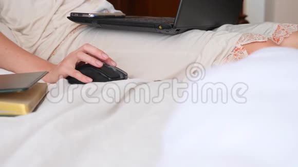生活方式自由职业者那个女人在家里的床上工作在一台笔记本电脑后面4k慢动作视频的预览图