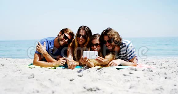 朋友们在沙滩上用手机自拍视频的预览图
