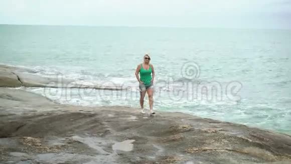 年轻女子走在海边视频的预览图