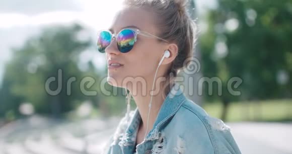 带着耳机的年轻女人在城市里享受时光视频的预览图