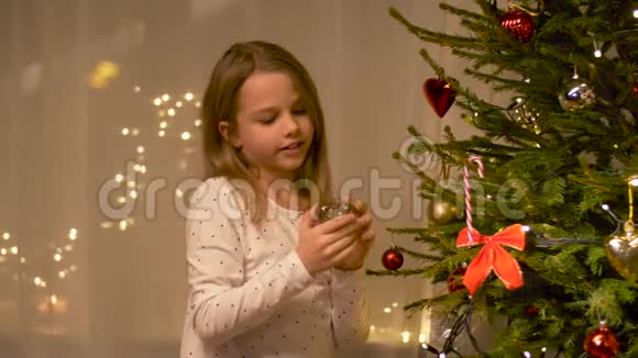 快乐女孩在家装饰圣诞树视频的预览图