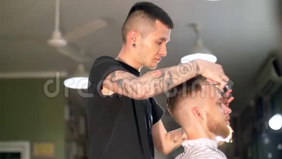 专业纹身理发师在理发店给他的客户理发视频的预览图