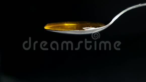 黑背景下从勺子流出的蜂蜜视频的预览图