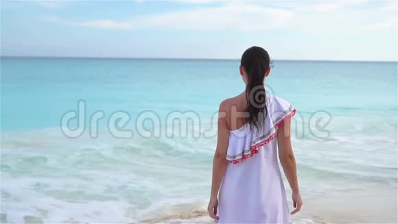 白色热带海滩上年轻美丽的女人在海边散步的女孩慢动作视频的预览图