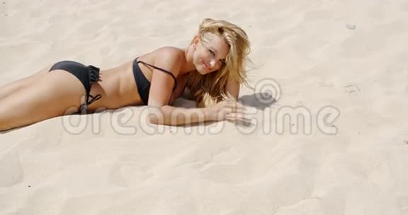 穿黑比基尼的女孩在沙滩上视频的预览图