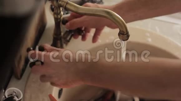男人洗盘子冲洗泡沫和洗涤剂的盘子视频的预览图