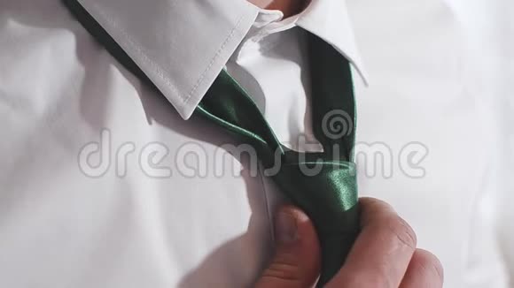 男人在白衬衫上系一条蓝领带视频的预览图