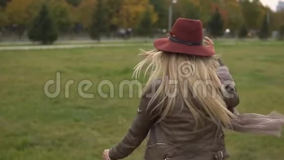 美丽的金发女孩在公园里散步视频的预览图
