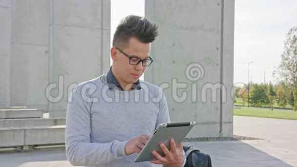 一个在外面用平板电脑的年轻人视频的预览图