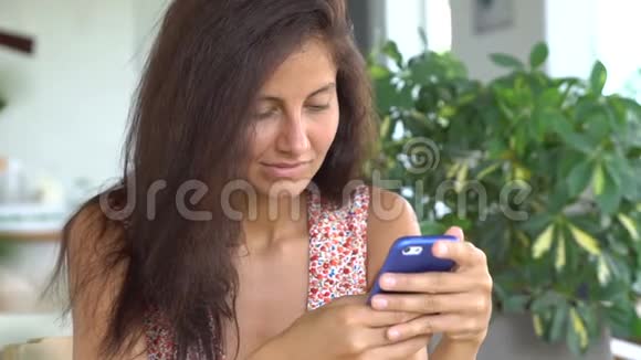 女人在咖啡馆里用智能手机购物视频的预览图