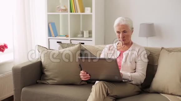 家里有台手提电脑的快乐高级女人视频的预览图