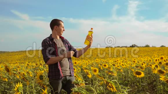 日落时分农夫的生活方式手捧一瓶葵花籽油慢动作视频农民农业视频的预览图