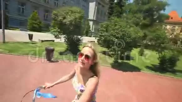 年轻的金发女人骑自行车视频的预览图