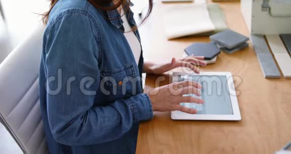 女高管坐在办公桌前使用数码平板电脑视频的预览图