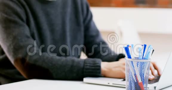 男性高管在办公桌上使用笔记本电脑视频的预览图
