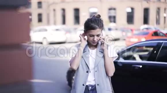 年轻女子在街上用智能手机说话视频的预览图