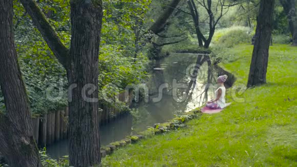 在河边做瑜伽练习的女人视频的预览图
