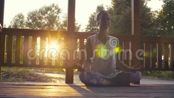 迷人的女人在日落时做瑜伽体式视频的预览图
