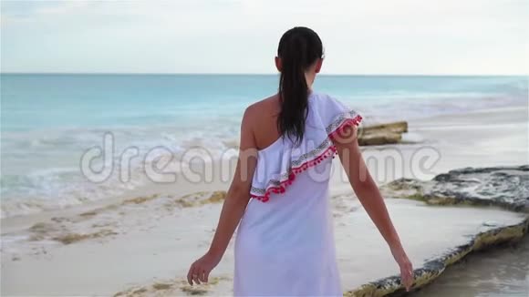 在白色热带海滩度假的年轻美女视频的预览图
