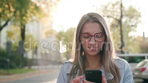 一位年轻女士在街上使用智能手机视频的预览图