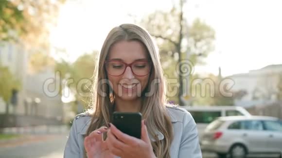 一位年轻女士在街上使用智能手机视频的预览图