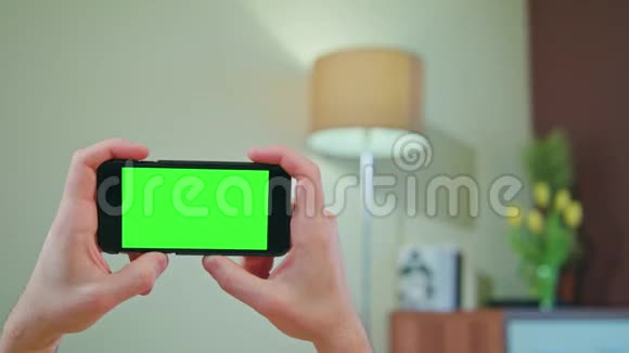 男性手拿着绿色屏幕的手机视频的预览图